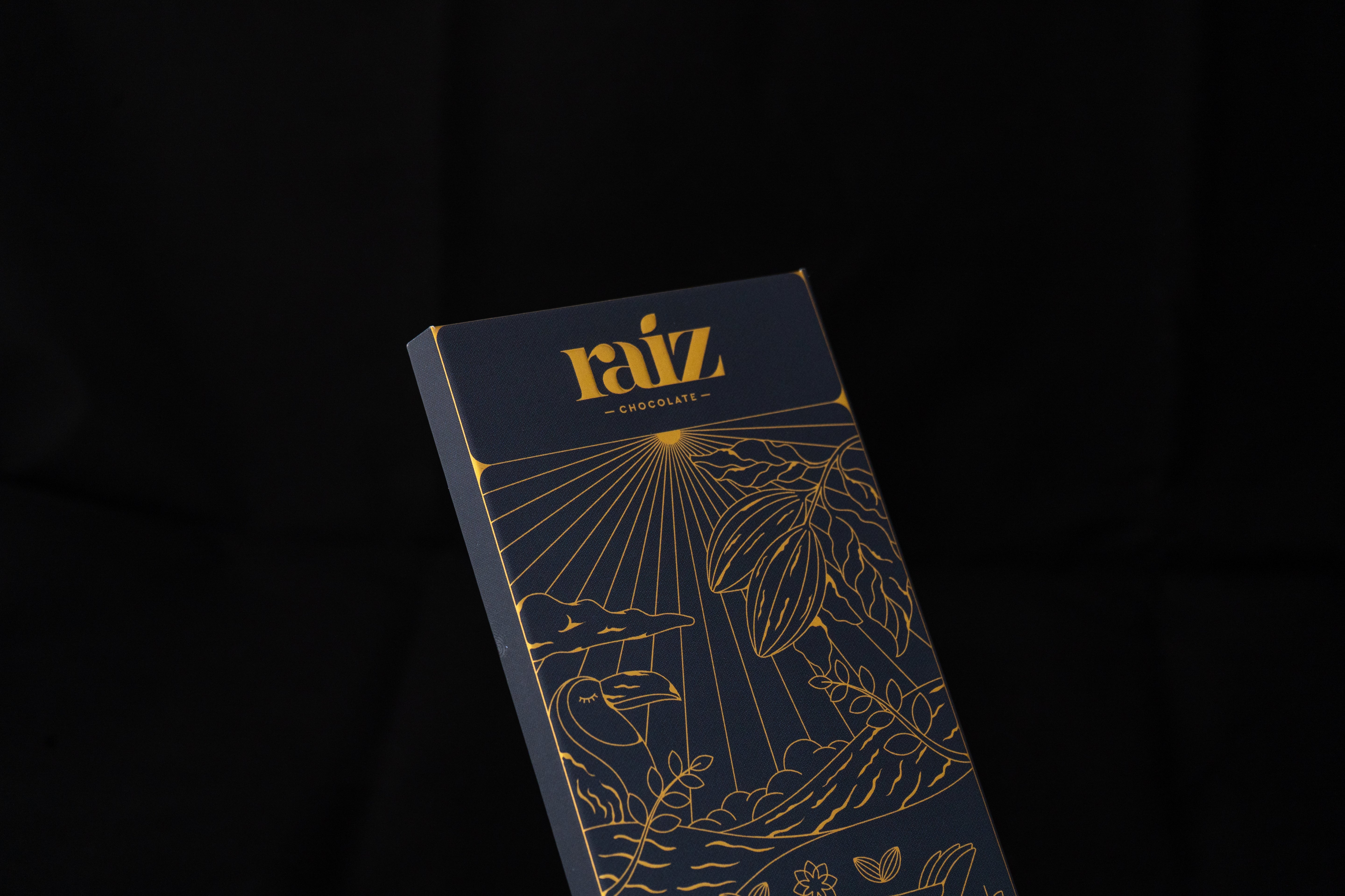 Dark blue chocolate  packaging with gold text and illustrations on a black background